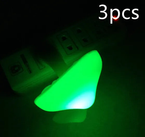 Mushroom-shaped LED night light with light sensor, warm yellow glow, plugging into a wall socket