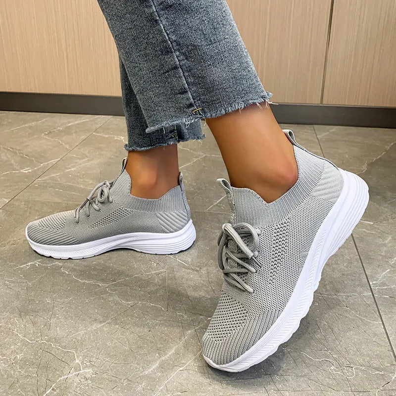 Women's low-top running shoes in Creamy White with mesh detailing and a flat rubber sole.