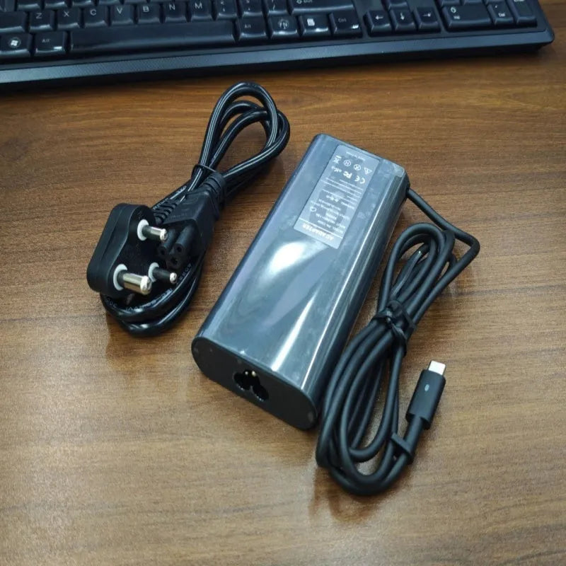 Black 65W USB-C laptop power adapter with set of international plug cords.