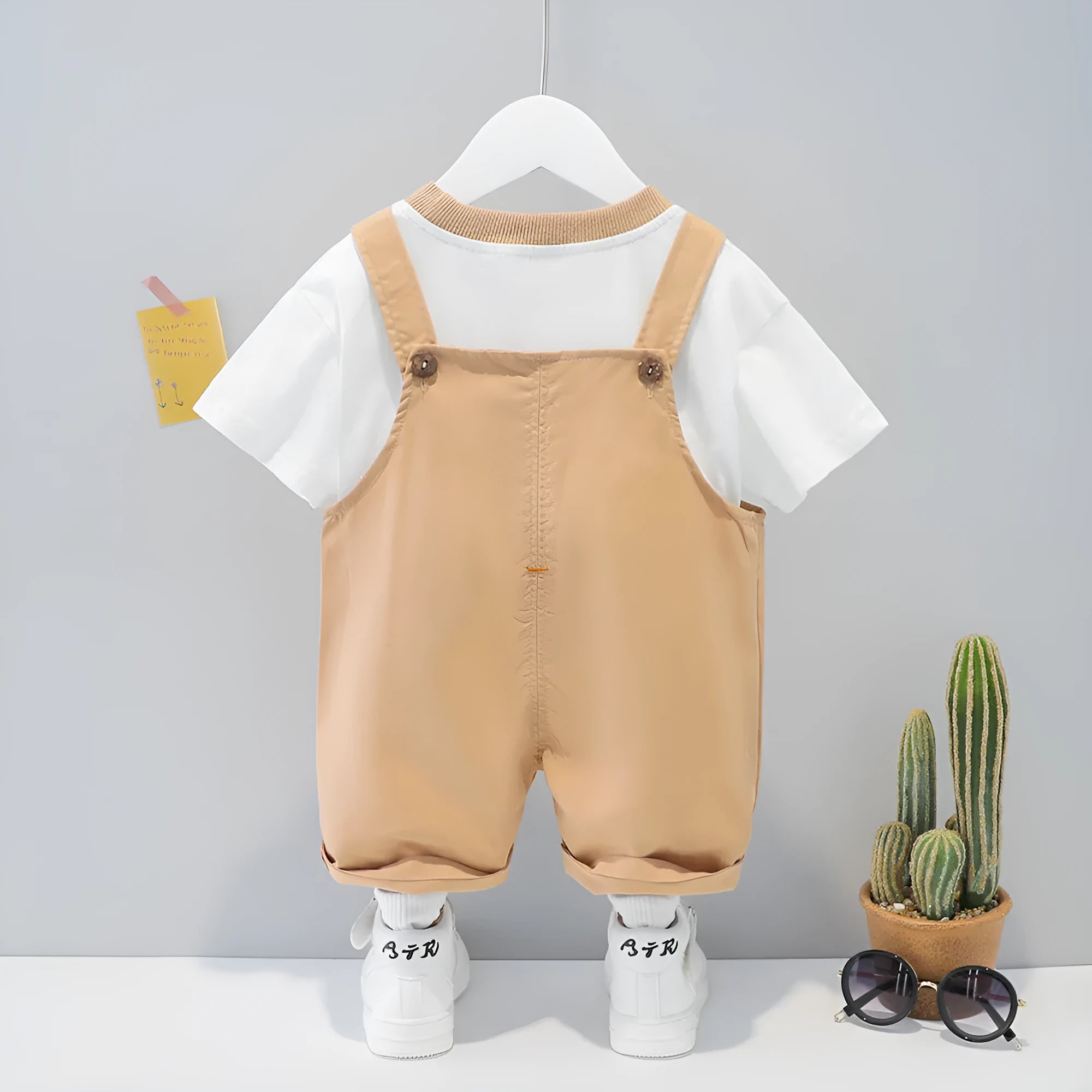 Baby wearing yellow cartoon short-sleeved overalls with adjustable straps