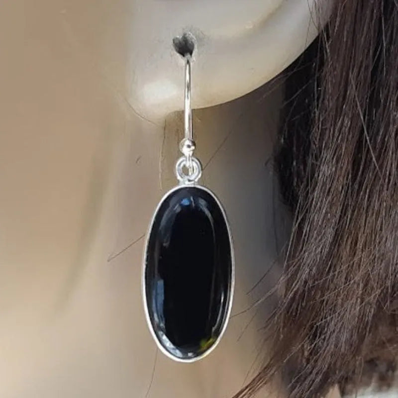 Black agate oval pendant earrings with geometric silver-toned frames and drop earring design
