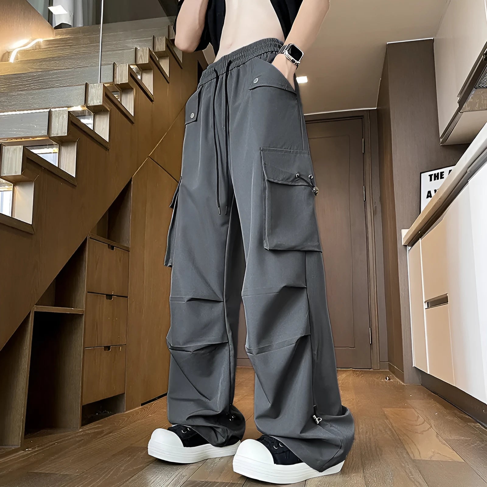 Women's plus size straight-leg waterproof trousers in black, showing drawstring waist and loose fit.