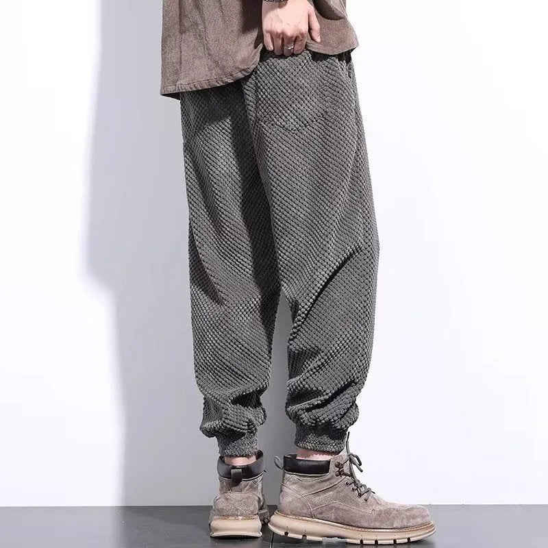 Men's grey ankle-tied straight-leg sweatpants laid flat, showing the tapered cut and tie detail.