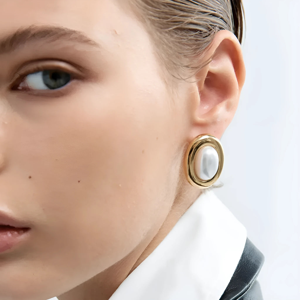 Close-up of women's stainless steel vintage pearl stud earrings with a silver-toned electroplated finish.