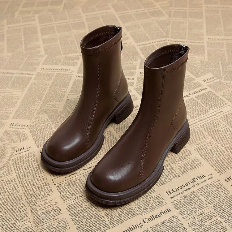 Women's black ankle boots with a flat thick heel, round toe, and a back zipper closure.