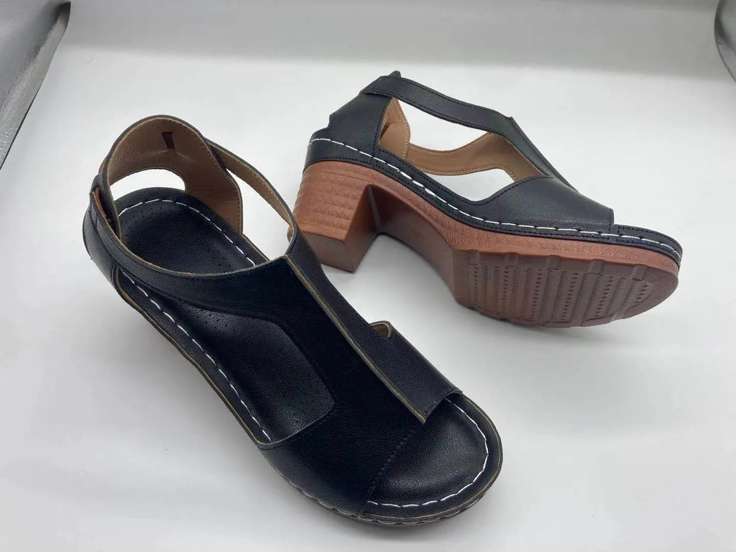Women's peep toe wedge sandals with buckle detail, low heel, on a white background.