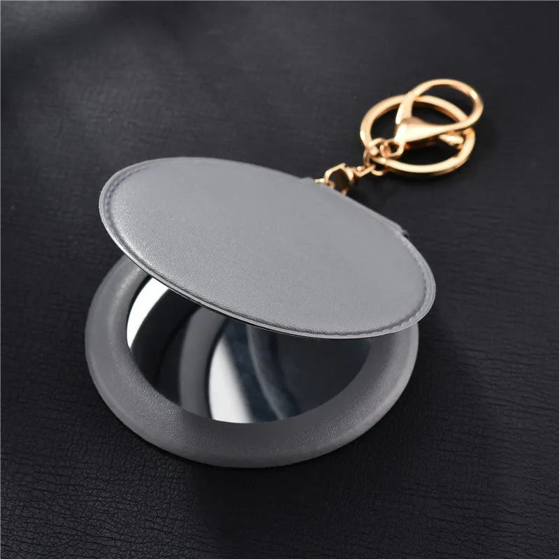 Compact round ladies leather makeup mirror with 8cm diameter glass surface and golden buckle