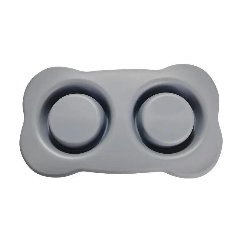 Large silicone double dog bowl in blue with two compartments for food and water on a kitchen floor.