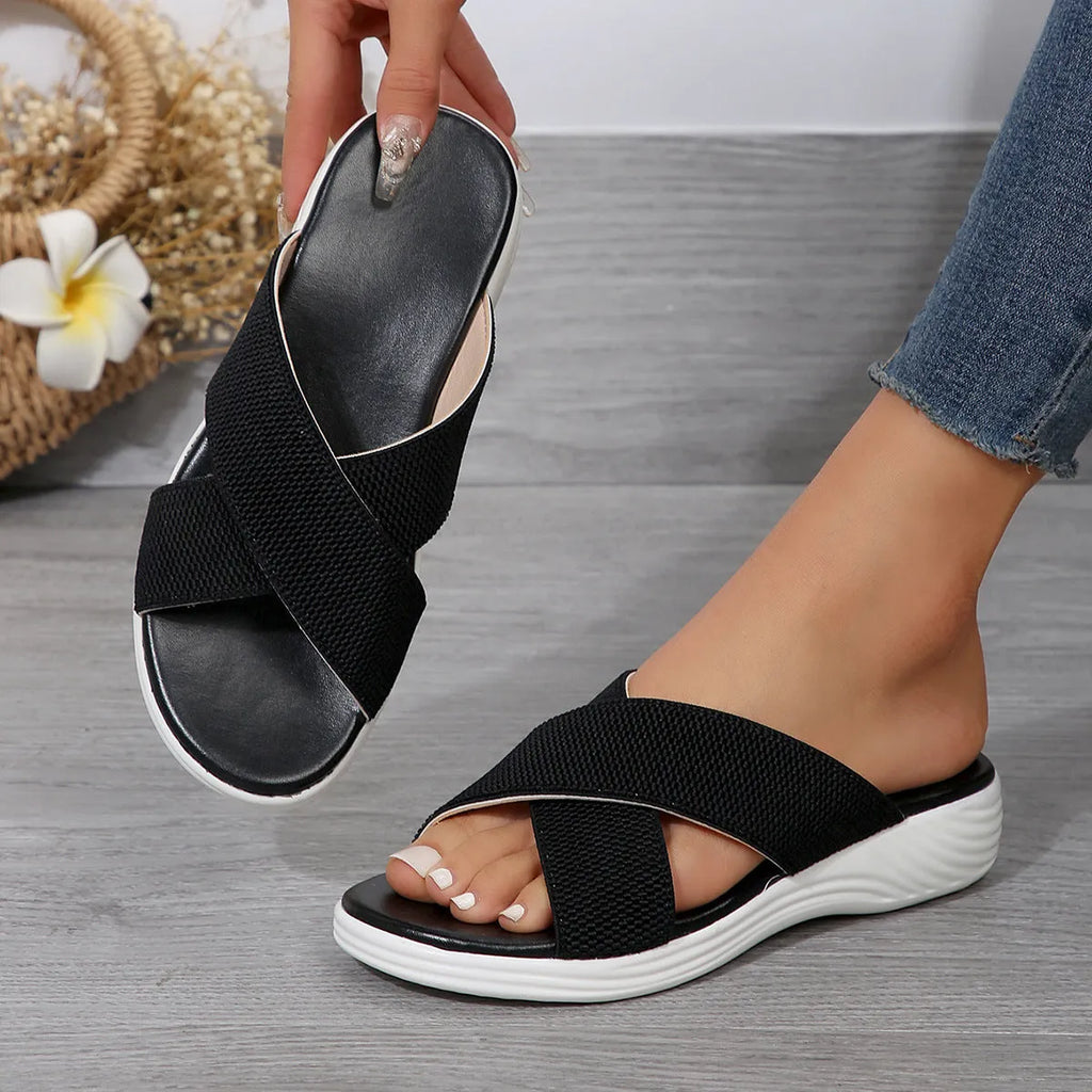 Women's black flat wedge slippers with peep-toe design and cross-strap detailing