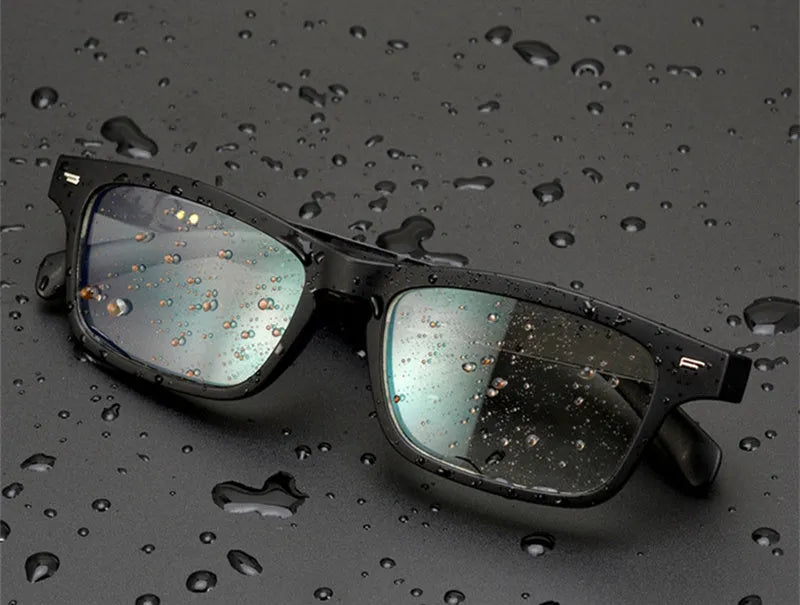 Smart glasses with tinted lenses featuring semi-open ear speakers and a Bluetooth microphone on the frame.