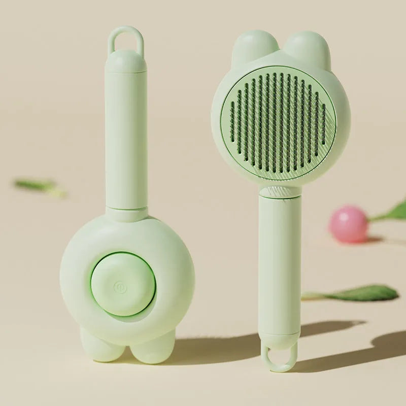 Self-cleaning pet grooming brush with green handle and stainless steel comb, showing the release button.