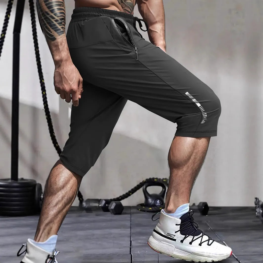 Man wearing grey cropped ice silk sports pants made from quick-dry nylon fabric.