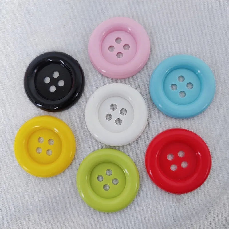 Assortment of oversized round plastic buttons in various colours with four holes.