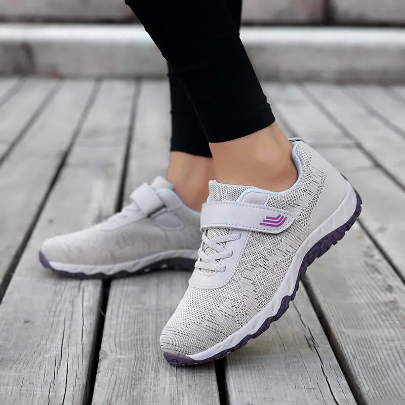 Women's grey purple low-top casual shoes with Velcro strap and wedge heel on a plain background.
