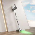 Light gray wireless handheld folding tube vacuum cleaner with LED light on a hard floor