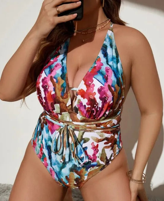 Purple and blue solid colour women's halter neck one-piece swimsuit on a hanger.