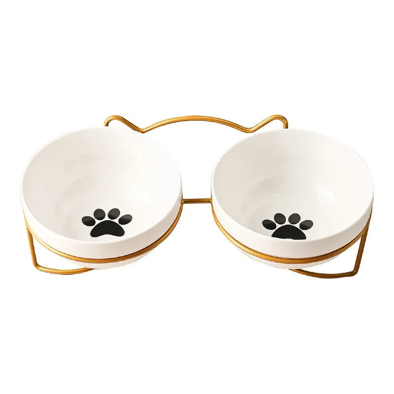 White ceramic cat bowl with cat paw print design on a black iron frame stand