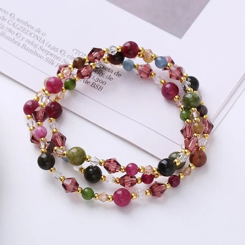 Women's adjustable bracelet with tourmaline, strawberry quartz, or amethyst crystal beads on a cord.