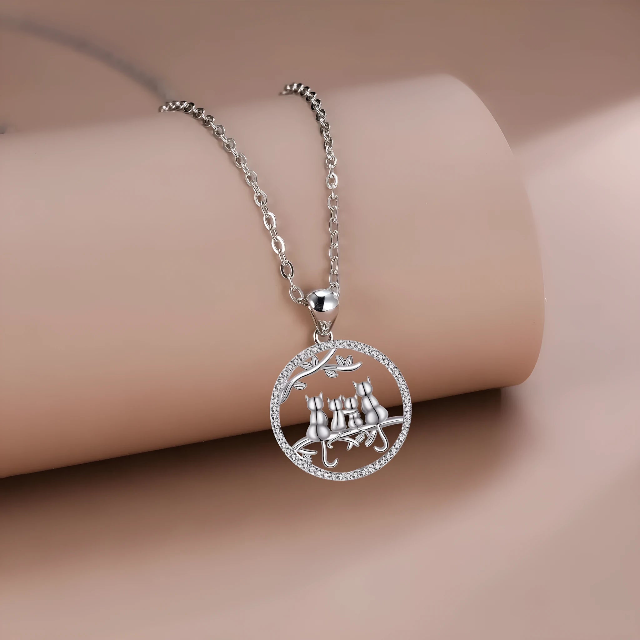 Copper necklace with a four-cat pendant on a textured cross chain, electroplated finish.