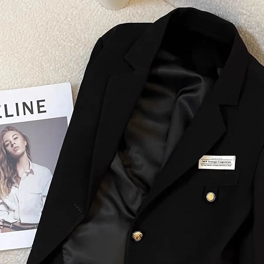 Black women's loose-fit suit coat with long sleeves and a pocket, made from polyester.