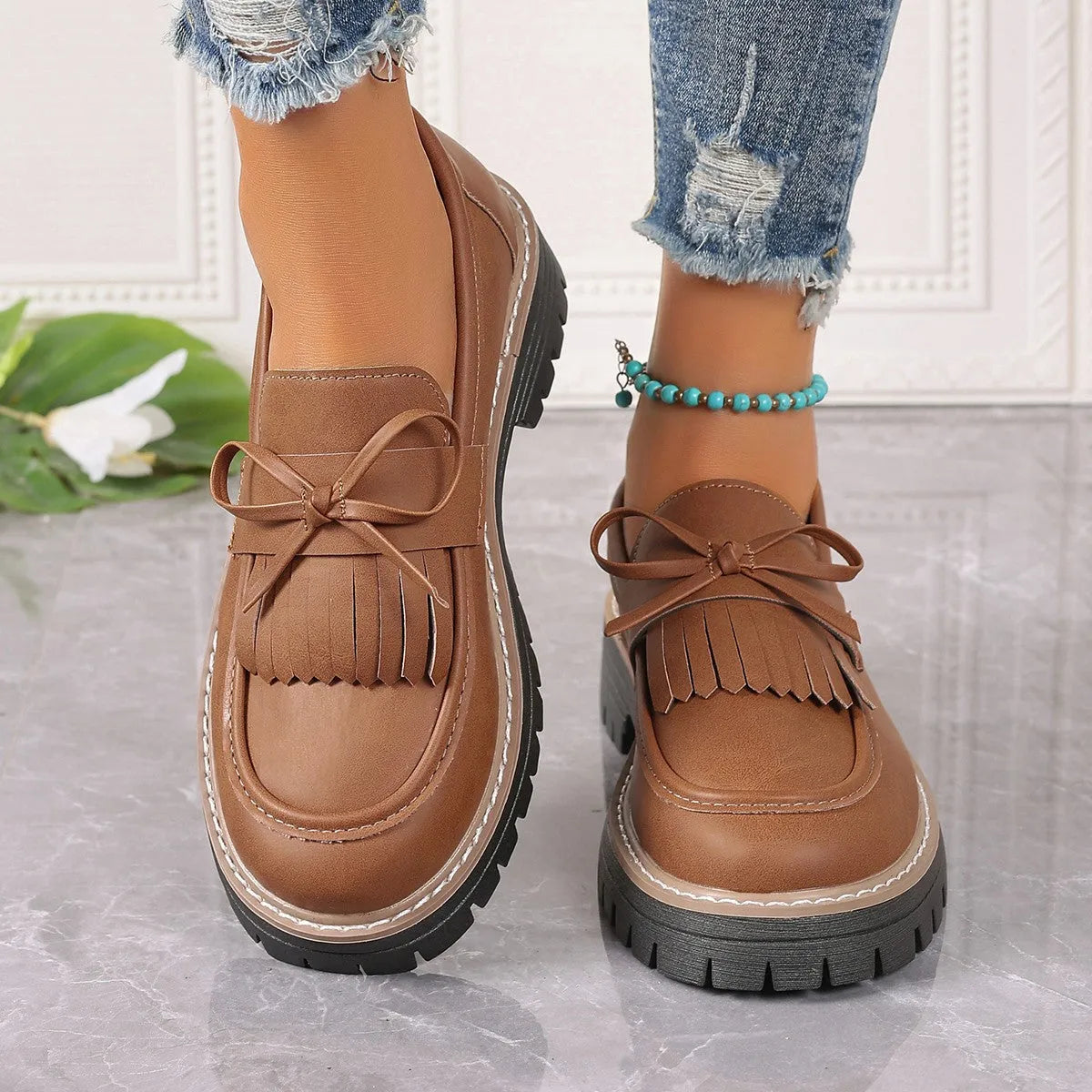 Black plus size women's loafers with tassel decoration, bowknot detail, and chunky rubber sole