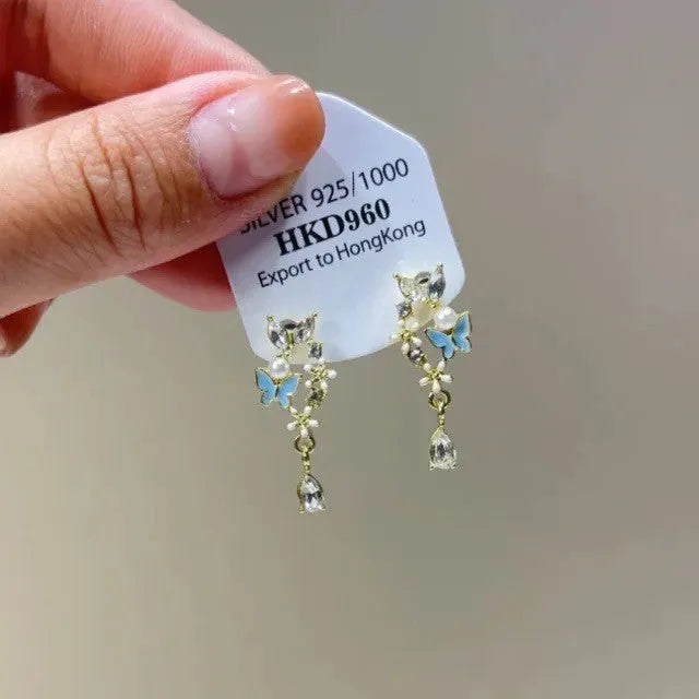Pair of geometric heart-shaped alloy ear clips with rhinestones and a tassel.