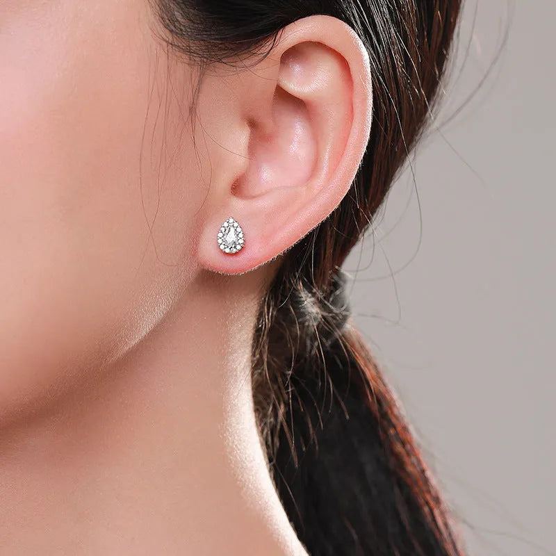 A pair of silver drop shape ear studs for women with a diamond-treated finish.