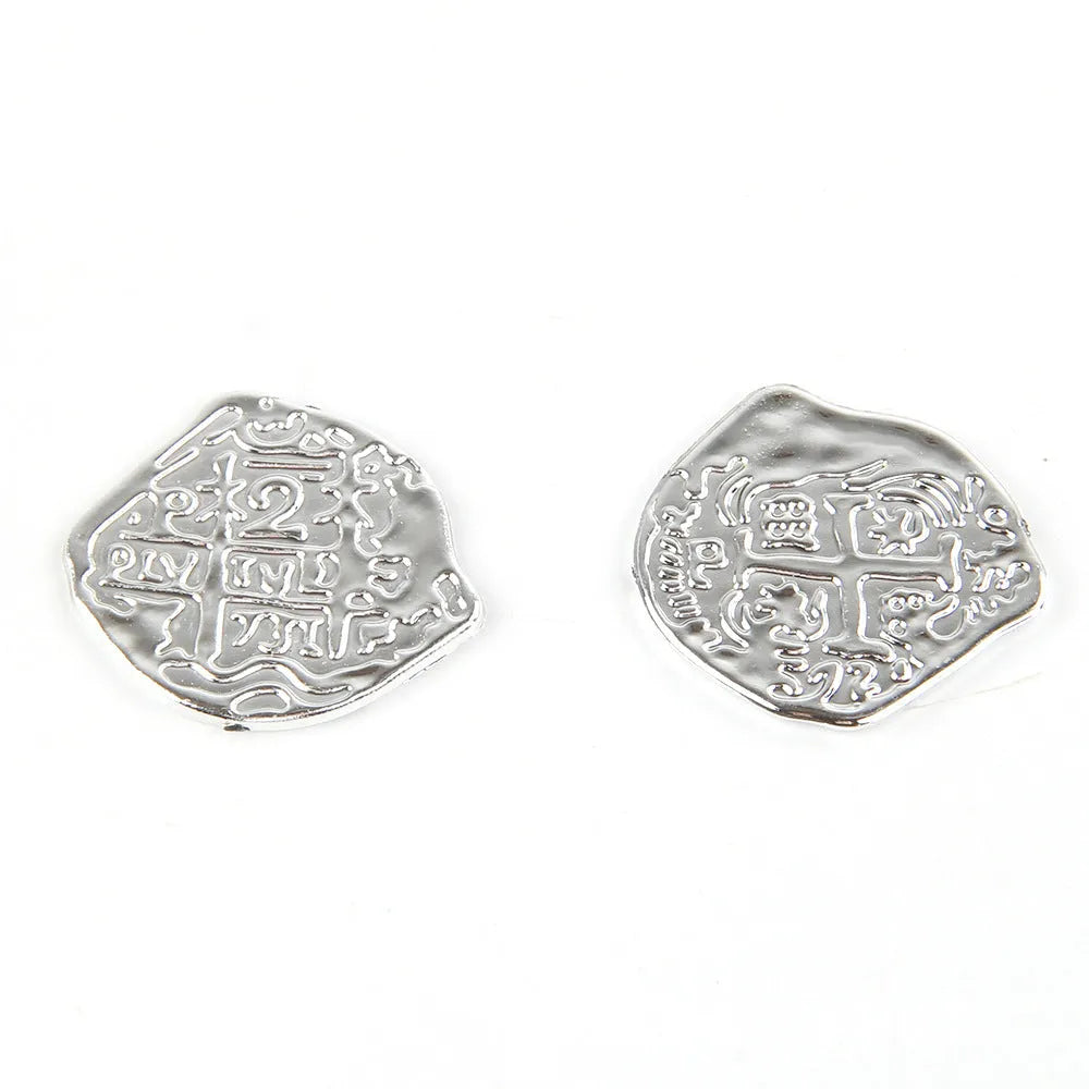 Three piles of plastic Roman coins replica in bronze, gold and silver finishes for pirate treasure decoration