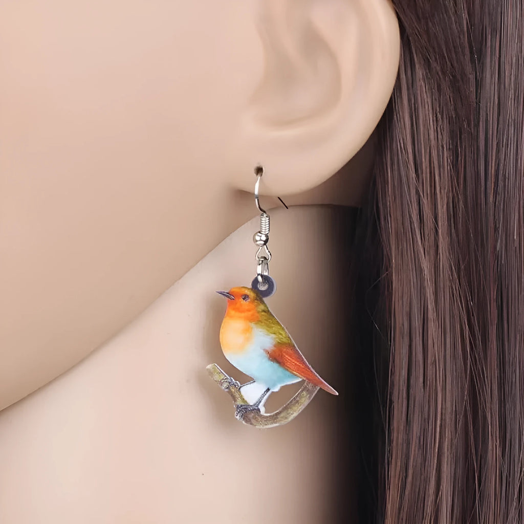 Blue Titmouse pendant earrings with geometric and snake designs on acrylic
