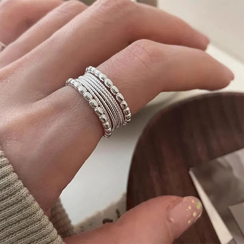 Copper geometric ring with woven twisted design and adjustable opening.
