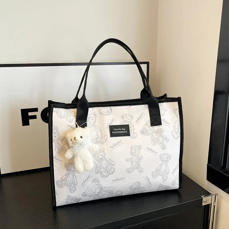 Women's black canvas tote bag with diamond pattern and shoulder strap
