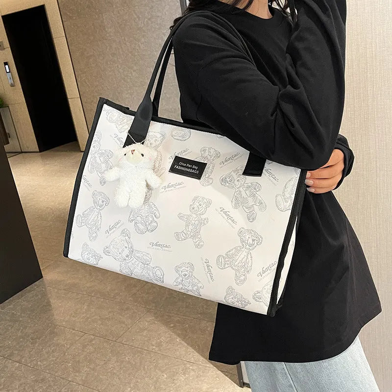 Women's black canvas tote bag with diamond pattern and shoulder strap