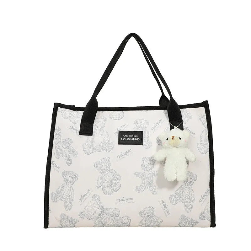 Women's black canvas tote bag with diamond pattern and shoulder strap