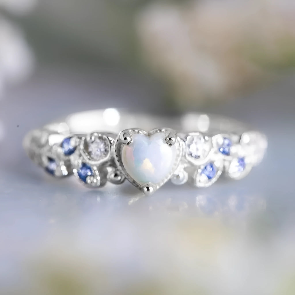White alloy women's heart ring with flower opal ocean design on model finger