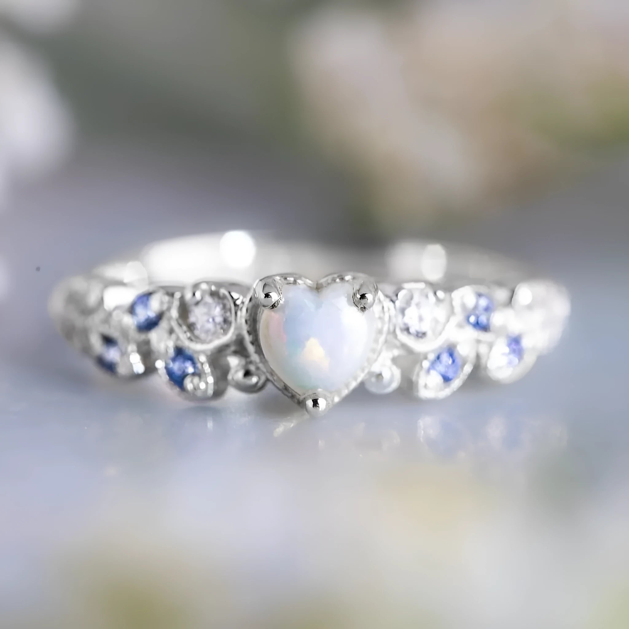 White alloy women's heart ring with flower opal ocean design on model finger