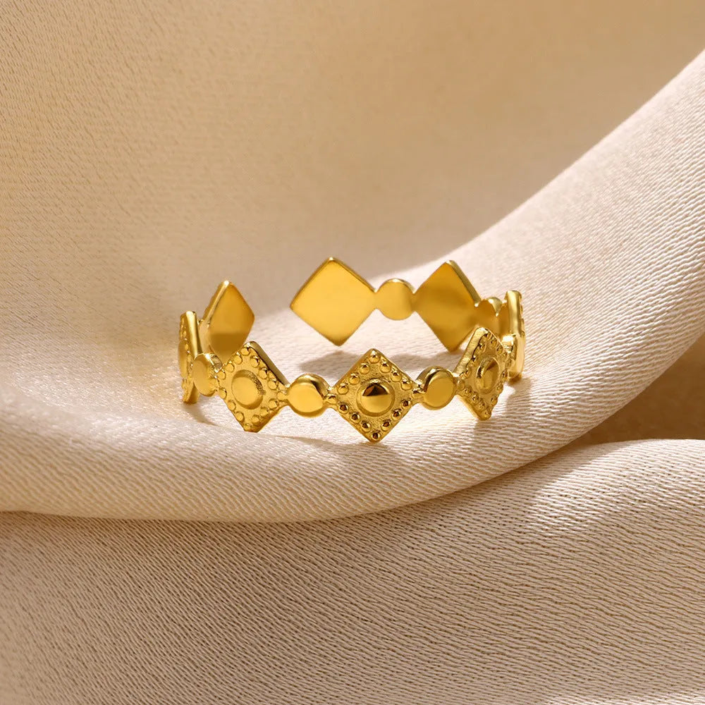Geometric titanium steel women's ring with gold diamond finish on grey background