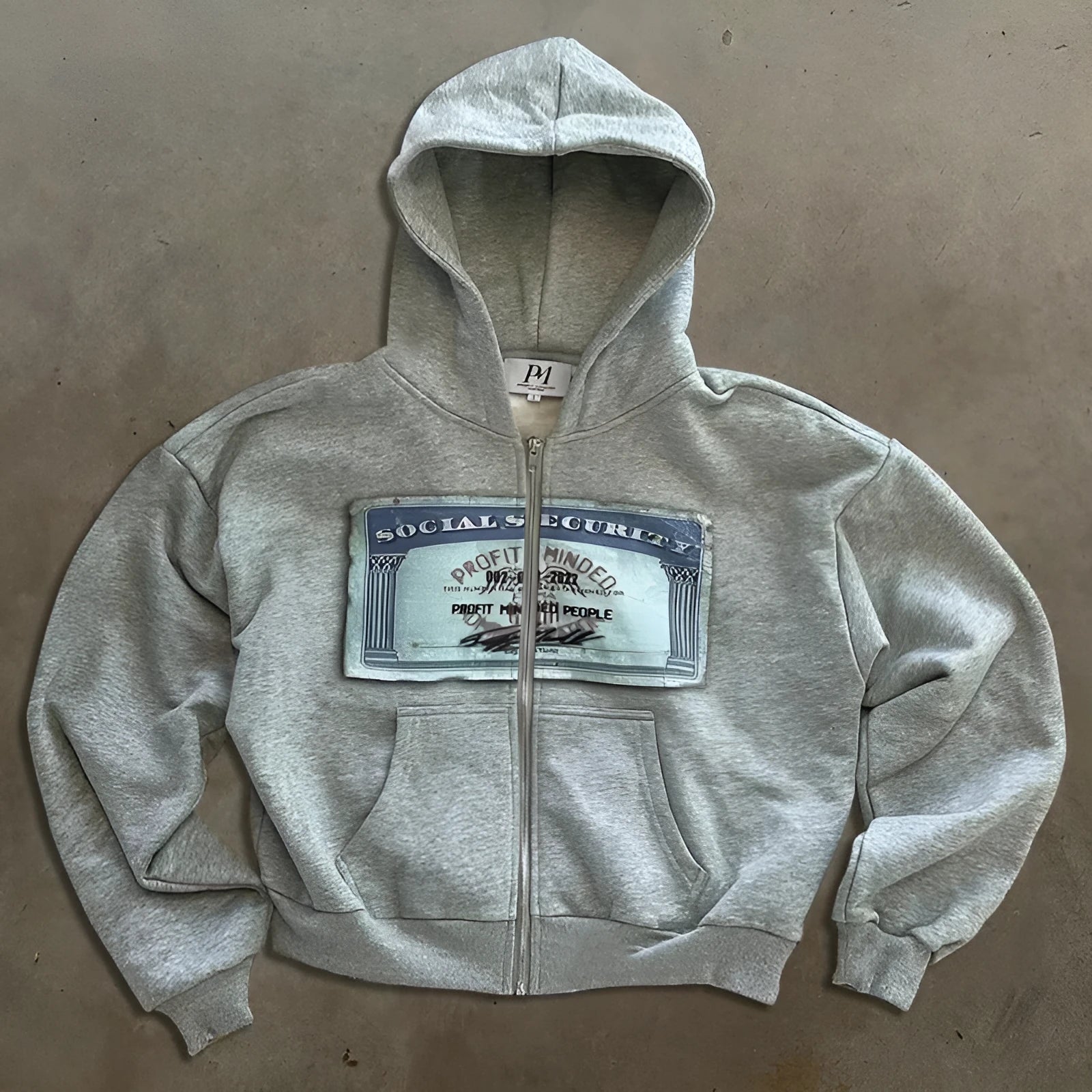 A loose fit black hoodie jacket with a front zipper, pockets, and a white letter print design.