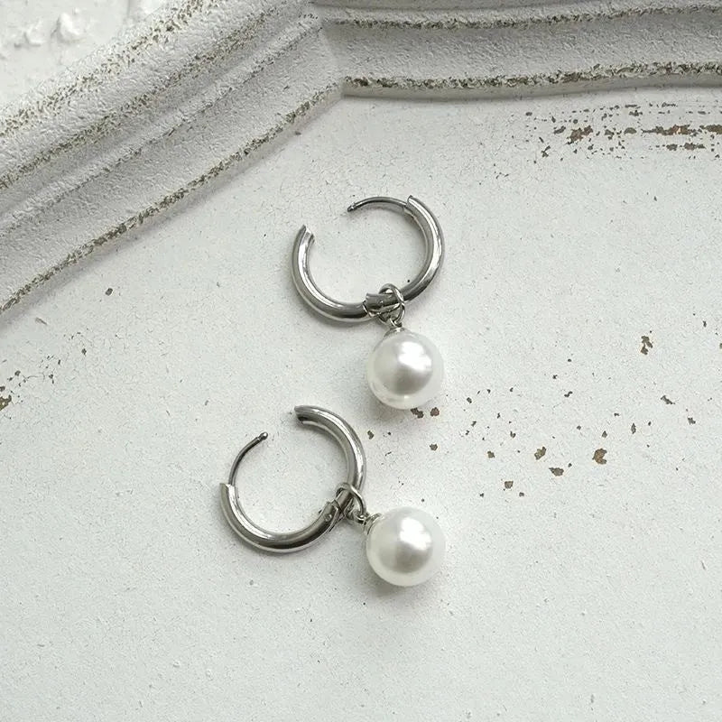 A pair of geometric-shaped women's alloy earrings with a round pearl charm, featuring titanium steel posts.