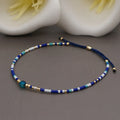 Handmade bohemian-style bracelet with semi-precious stone and colourful glass beads on a wrist.