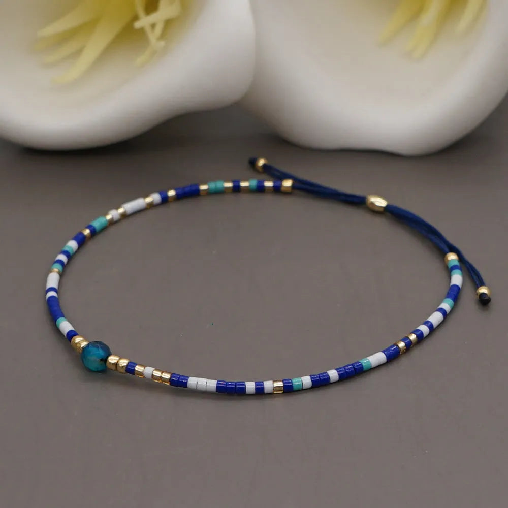Handmade bohemian-style bracelet with semi-precious stone and colourful glass beads on a wrist.