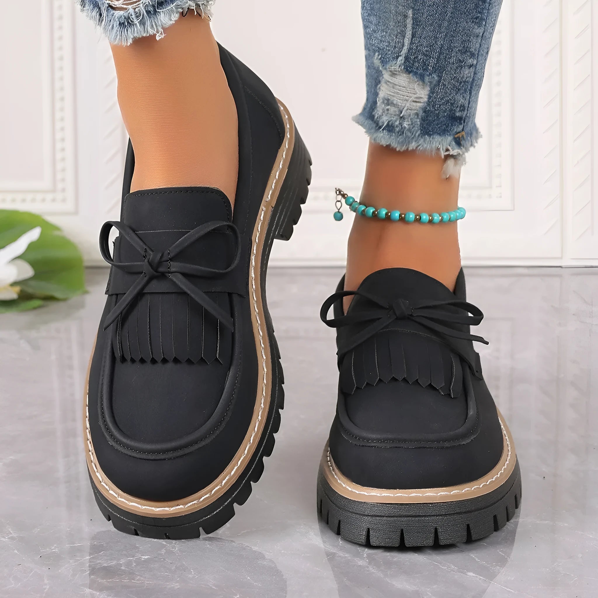 Black plus size women's loafers with tassel decoration, bowknot detail, and chunky rubber sole