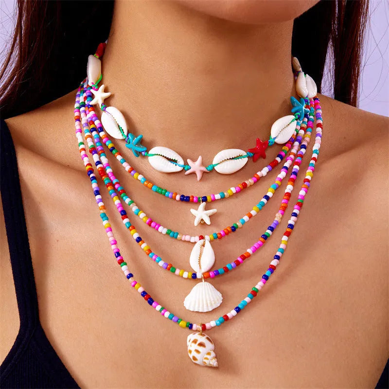 Five multi-layer beaded necklaces with starfish and shell charms in blue and colours