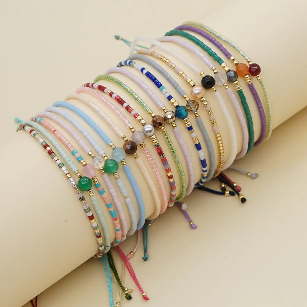 Handmade bohemian-style bracelet with semi-precious stone and colourful glass beads on a wrist.