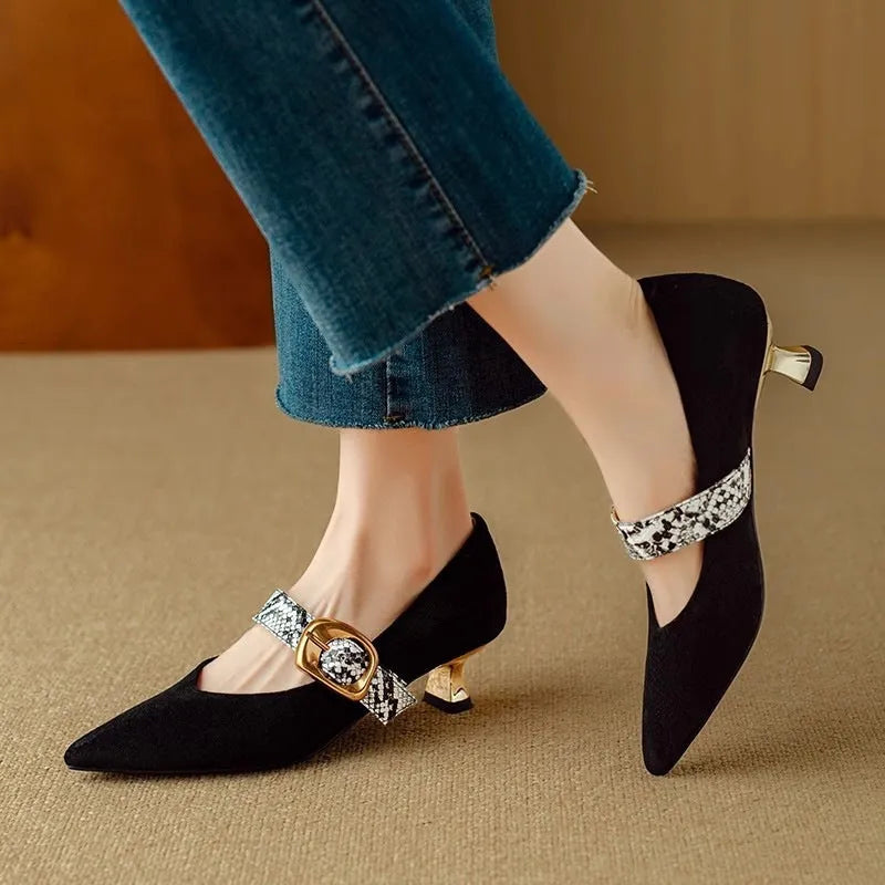 Black pointed toe stiletto high heels with a buckle strap across the instep.