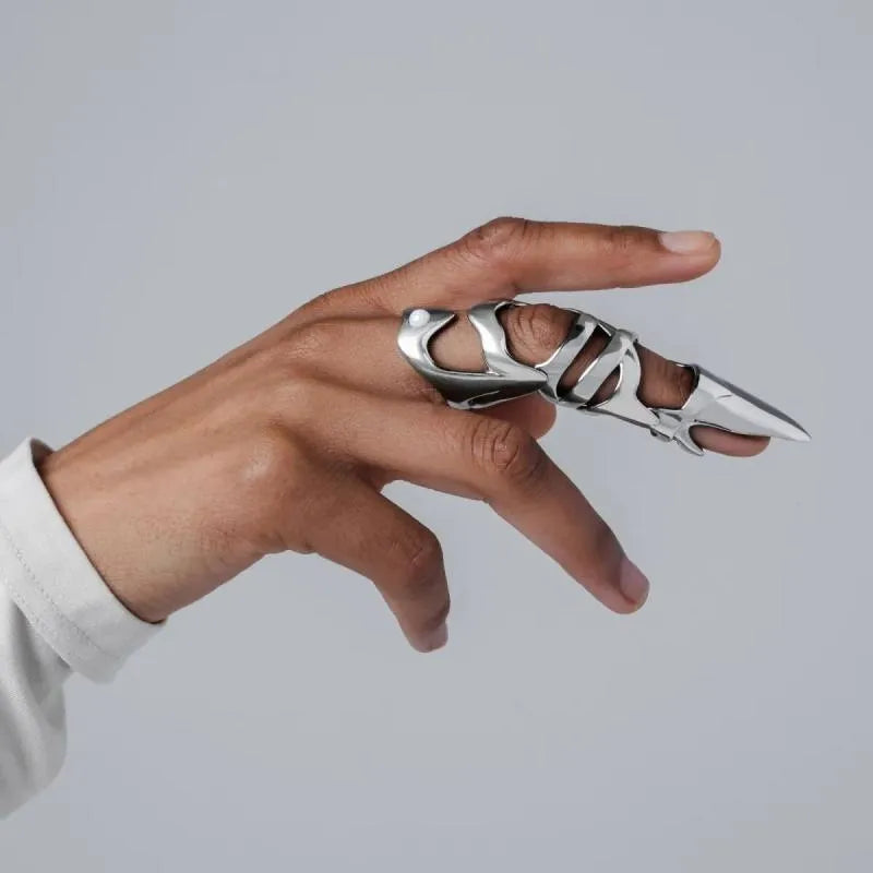 Silver punk armour finger stall ring made of alloy, shown on a finger.