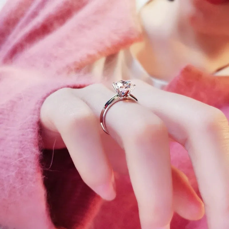 White gold plated women's ring with a geometric design and a six-claw set zircon stone.