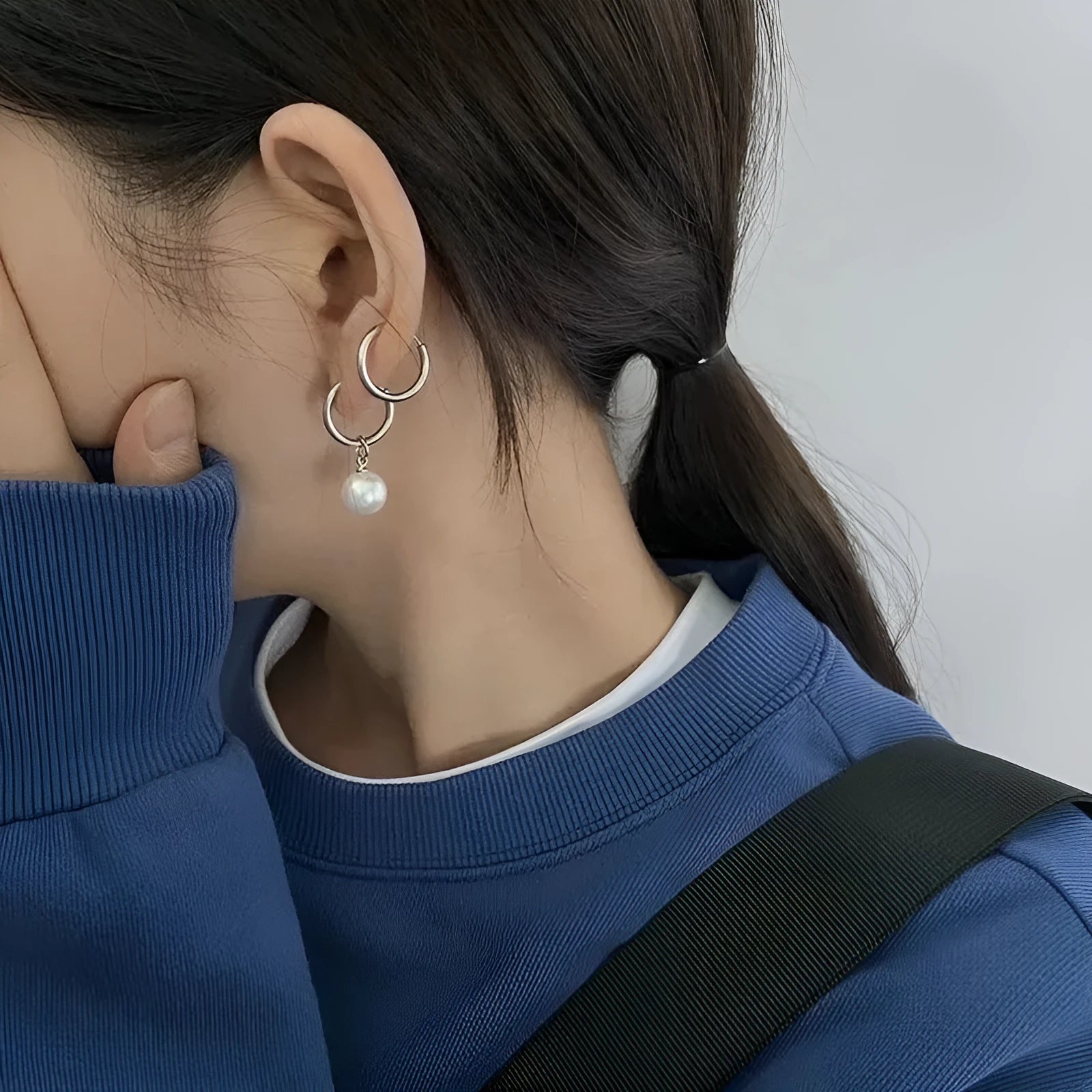 A pair of geometric-shaped women's alloy earrings with a round pearl charm, featuring titanium steel posts.
