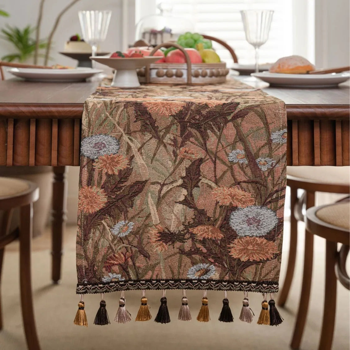 Beige jacquard fabric table runner with long tassels and a woven floral leaf pattern.