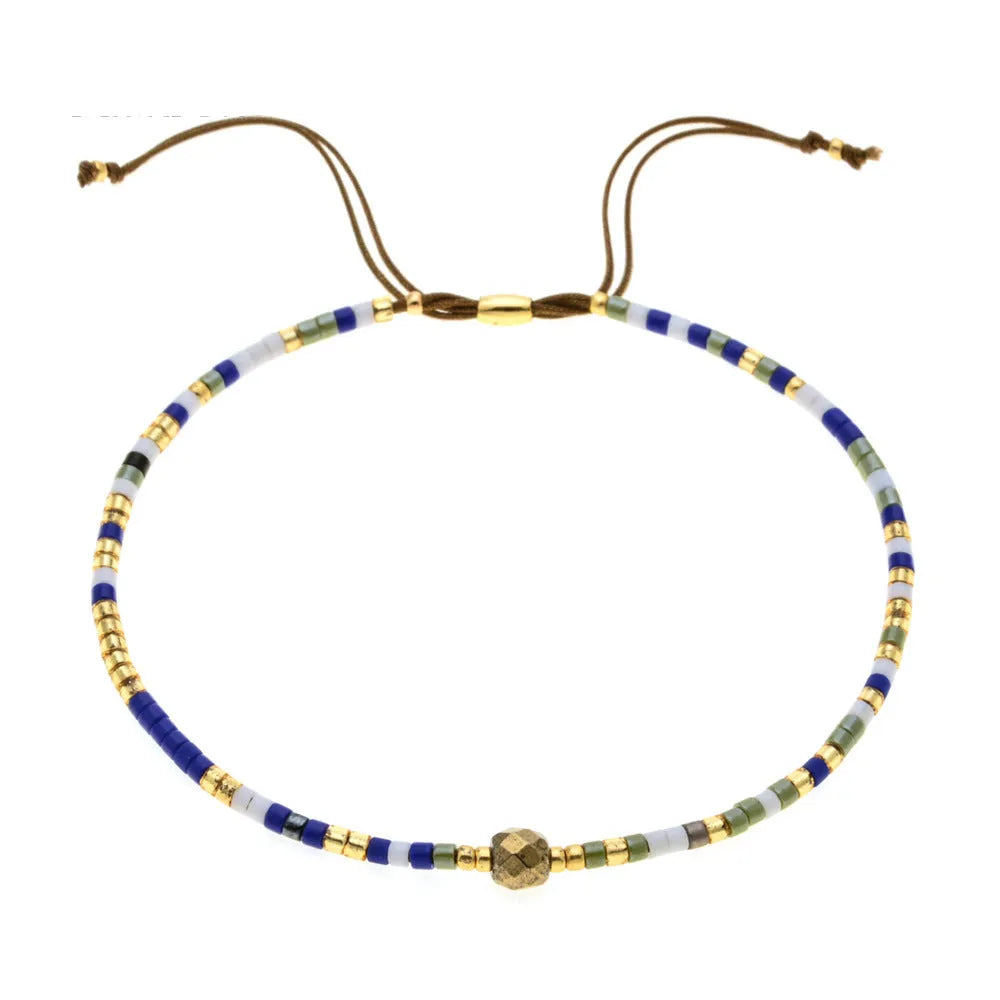 Handmade bohemian-style bracelet with semi-precious stone and colourful glass beads on a wrist.