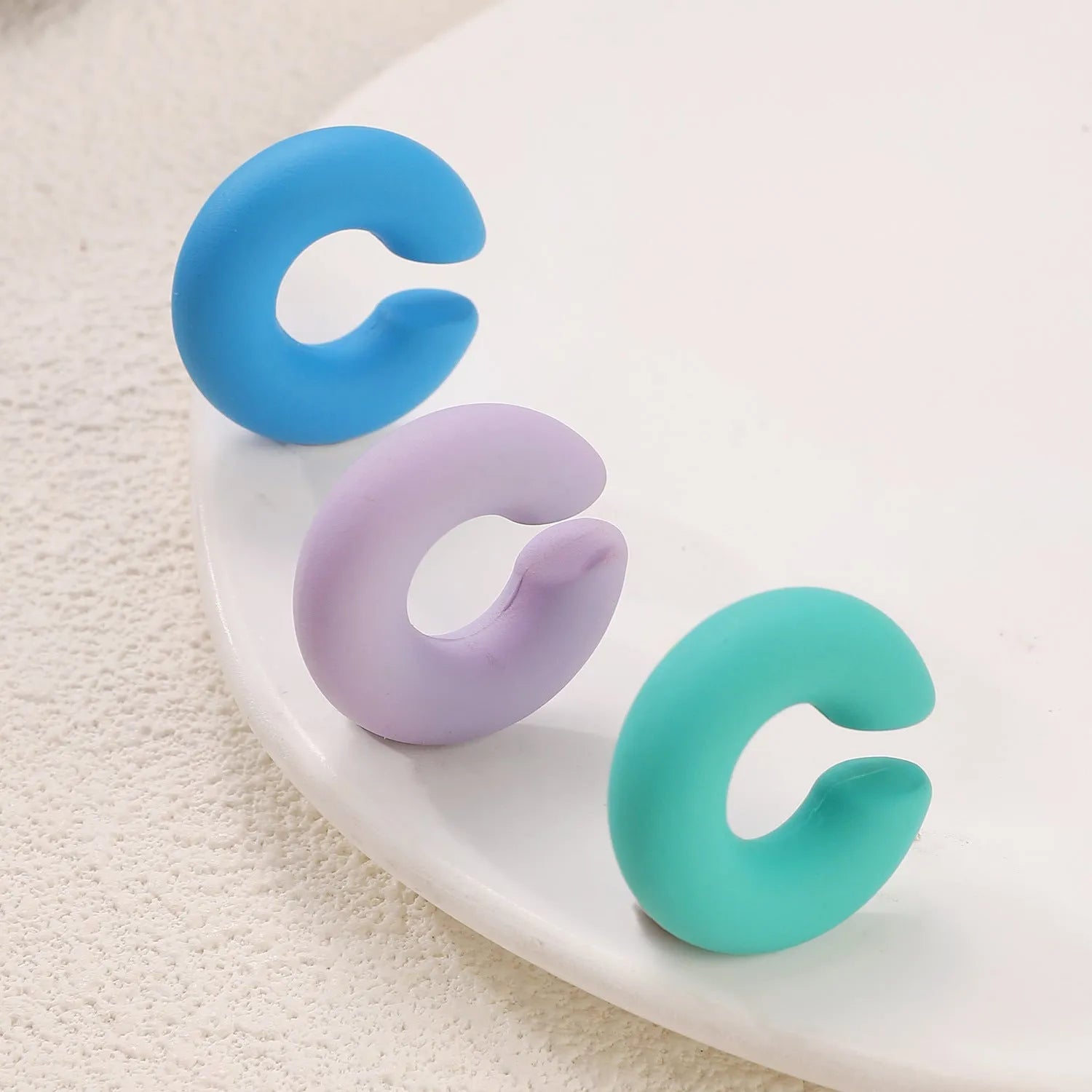 Geometric C-shape clip-on earrings with matte coarse finish in candy colours for women without pierced ears